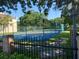 Community tennis court with green fencing, mature trees, and shaded sidewalks at 115 Brent Cir, Oldsmar, FL 34677