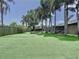 Wide view of yard with green artificial turf, privacy fence, mature trees, and patio at 11525 Country Oaks Dr, Tampa, FL 33618