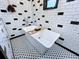 A freestanding tub is the focal point of this renovated bathroom, featuring eye-catching black and white tilework at 11525 Country Oaks Dr, Tampa, FL 33618
