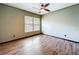 A cozy bedroom with a large window features neutral walls and stylish, modern wood-look laminate flooring at 11525 Country Oaks Dr, Tampa, FL 33618