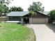 Charming single-story home with a well-manicured lawn and an attached two-car garage at 11525 Country Oaks Dr, Tampa, FL 33618