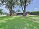 Inviting exterior view of house with a lush green lawn and mature trees at 11525 Country Oaks Dr, Tampa, FL 33618