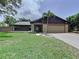 Lovely home with beautiful landscaping, a two-car garage, and a welcoming front entrance at 11525 Country Oaks Dr, Tampa, FL 33618