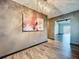 Stylish hallway showcasing wood flooring, modern artwork, and a view into an adjacent living space at 11525 Country Oaks Dr, Tampa, FL 33618