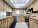 Kitchen with wood cabinets, stainless steel appliances, and bright skylight at 11525 Country Oaks Dr, Tampa, FL 33618