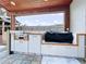 Well-equipped outdoor kitchen with grill, white cabinets and covered patio for cooking and entertaining at 11525 Country Oaks Dr, Tampa, FL 33618