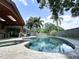 Stunning pool area with a spa, lush landscaping, and an outdoor kitchen, perfect for entertaining at 11525 Country Oaks Dr, Tampa, FL 33618