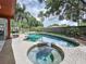 Gorgeous backyard with a pool and spa, surrounded by lush landscaping for a private oasis at 11525 Country Oaks Dr, Tampa, FL 33618
