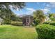 Backyard view showcasing lush tropical landscaping, a screened patio, and privacy fencing at 11849 Forest Park Cir, Bradenton, FL 34211