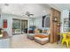 Open-concept living room features tile flooring, a sectional sofa, and access to outdoor area at 11849 Forest Park Cir, Bradenton, FL 34211