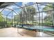 Enclosed screen patio with ample sunlight, spacious layout, and a trampoline for recreational activities at 11849 Forest Park Cir, Bradenton, FL 34211