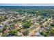 Expansive aerial view of a residential neighborhood with tree-lined streets and glimpses of a nearby lake and commercial district at 1220 Magnolia Dr, Clearwater, FL 33756