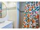 Stylish bathroom featuring a shower with vibrant curtain, modern sink and vanity, and contemporary fixtures at 1220 Magnolia Dr, Clearwater, FL 33756
