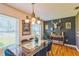 Bright dining room with hardwood floors, modern lighting fixture, and stylish decorations on a dark accent wall at 1220 Magnolia Dr, Clearwater, FL 33756