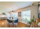 Dining room with a modern light fixture, blond hardwood floors, and a large window for plenty of natural light at 1220 Magnolia Dr, Clearwater, FL 33756
