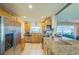 Kitchen featuring stainless steel appliances, granite countertops, and light wood cabinets at 1220 Magnolia Dr, Clearwater, FL 33756