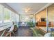 Bright sunroom with large windows, geometric tile floor, and an adjacent living area perfect for relaxing or working at 1220 Magnolia Dr, Clearwater, FL 33756
