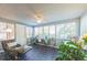 Bright sunroom with geometric tile floor, large windows, ceiling fan, and comfortable chair with ottoman at 1220 Magnolia Dr, Clearwater, FL 33756