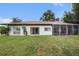 Spacious backyard featuring a screened lanai and lush lawn at 13013 Sawmill Way, Hudson, FL 34667