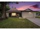 Well-maintained home exterior with an attached garage and large shade tree at 13013 Sawmill Way, Hudson, FL 34667