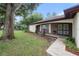 Inviting home exterior with a covered porch and large shade tree at 13013 Sawmill Way, Hudson, FL 34667