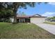 Charming single-story home with a well-maintained lawn, mature tree and an attached two-car garage at 13013 Sawmill Way, Hudson, FL 34667