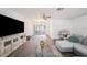 Spacious living room featuring wood-look floors, a gray sectional sofa, and a large screen television at 13013 Sawmill Way, Hudson, FL 34667