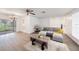 Open living space with wood-look flooring, a plush gray sofa, and sliding glass doors leading to a lanai at 13013 Sawmill Way, Hudson, FL 34667