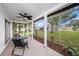 A screened patio offers an outdoor living space with views of the landscaped yard at 13013 Sawmill Way, Hudson, FL 34667