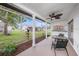 View of a screened lanai featuring a ceiling fan and an outdoor dining set at 13013 Sawmill Way, Hudson, FL 34667