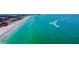 Scenic beach view featuring soft sands meeting tranquil turquoise ocean waters, complemented by nearby residential buildings at 15000 Gulf Blvd # 901, Madeira Beach, FL 33708