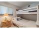 Bright bedroom showcasing a bunk bed, side table and a sunny window at 15000 Gulf Blvd # 901, Madeira Beach, FL 33708