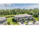 Aerial view of townhomes with manicured lawns, pond, and ample parking at 17592 Nectar Flume Dr, Land O Lakes, FL 34638