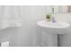 Clean, modern bathroom with a pedestal sink, fresh white paint, and contemporary fixtures at 17592 Nectar Flume Dr, Land O Lakes, FL 34638