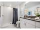 Bright bathroom with granite countertop, white cabinets, and a walk-in shower at 17592 Nectar Flume Dr, Land O Lakes, FL 34638