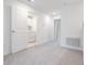 Bright, carpeted bedroom with neutral walls and a glimpse into the laundry room at 17592 Nectar Flume Dr, Land O Lakes, FL 34638