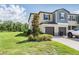 Attractive home featuring a lush lawn, tree, and a driveway leading to the attached two-car garage at 17592 Nectar Flume Dr, Land O Lakes, FL 34638