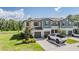 Inviting townhouse with a two-car garage, landscaped yard, and view of the adjacent pond at 17592 Nectar Flume Dr, Land O Lakes, FL 34638