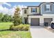 Charming townhome showcasing a well-manicured lawn, two car garage, and inviting facade under a blue sky at 17592 Nectar Flume Dr, Land O Lakes, FL 34638