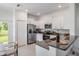 Modern kitchen featuring stainless steel appliances, granite countertops, white cabinets, and access to the outdoor area at 17592 Nectar Flume Dr, Land O Lakes, FL 34638