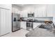 Contemporary kitchen with stainless steel appliances, granite countertops, and white cabinets at 17592 Nectar Flume Dr, Land O Lakes, FL 34638