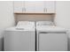 Well-organized laundry area with white washer and dryer and storage cabinets above at 17592 Nectar Flume Dr, Land O Lakes, FL 34638