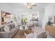 Comfortable living room featuring a plush sofa, stylish decor, and seamless transition to the kitchen and dining at 17592 Nectar Flume Dr, Land O Lakes, FL 34638