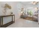Bright living room with neutral decor, tile flooring, a cozy sofa, and stylish decorative accents at 17592 Nectar Flume Dr, Land O Lakes, FL 34638