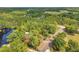 Lush aerial view of forested neighborhood, showcasing serene lake nestled among the verdant landscape at 18324 Jorene Rd, Odessa, FL 33556
