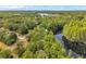 Lush aerial view of forested neighborhood, showcasing serene lake nestled among the verdant landscape at 18324 Jorene Rd, Odessa, FL 33556
