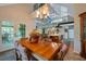 Elegant dining room with a large wooden table and chandelier, open to the living area at 18324 Jorene Rd, Odessa, FL 33556