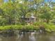 Charming home exterior with a beautiful lake view surrounded by lush greenery and trees at 18324 Jorene Rd, Odessa, FL 33556