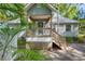 Front porch with blue door and inviting stairs framed by tropical palm foliage at 18324 Jorene Rd, Odessa, FL 33556
