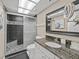 Well-lit bathroom with granite countertop, modern sink, tiled shower, and glass door at 18610 Gulf Blvd # 208, Indian Shores, FL 33785